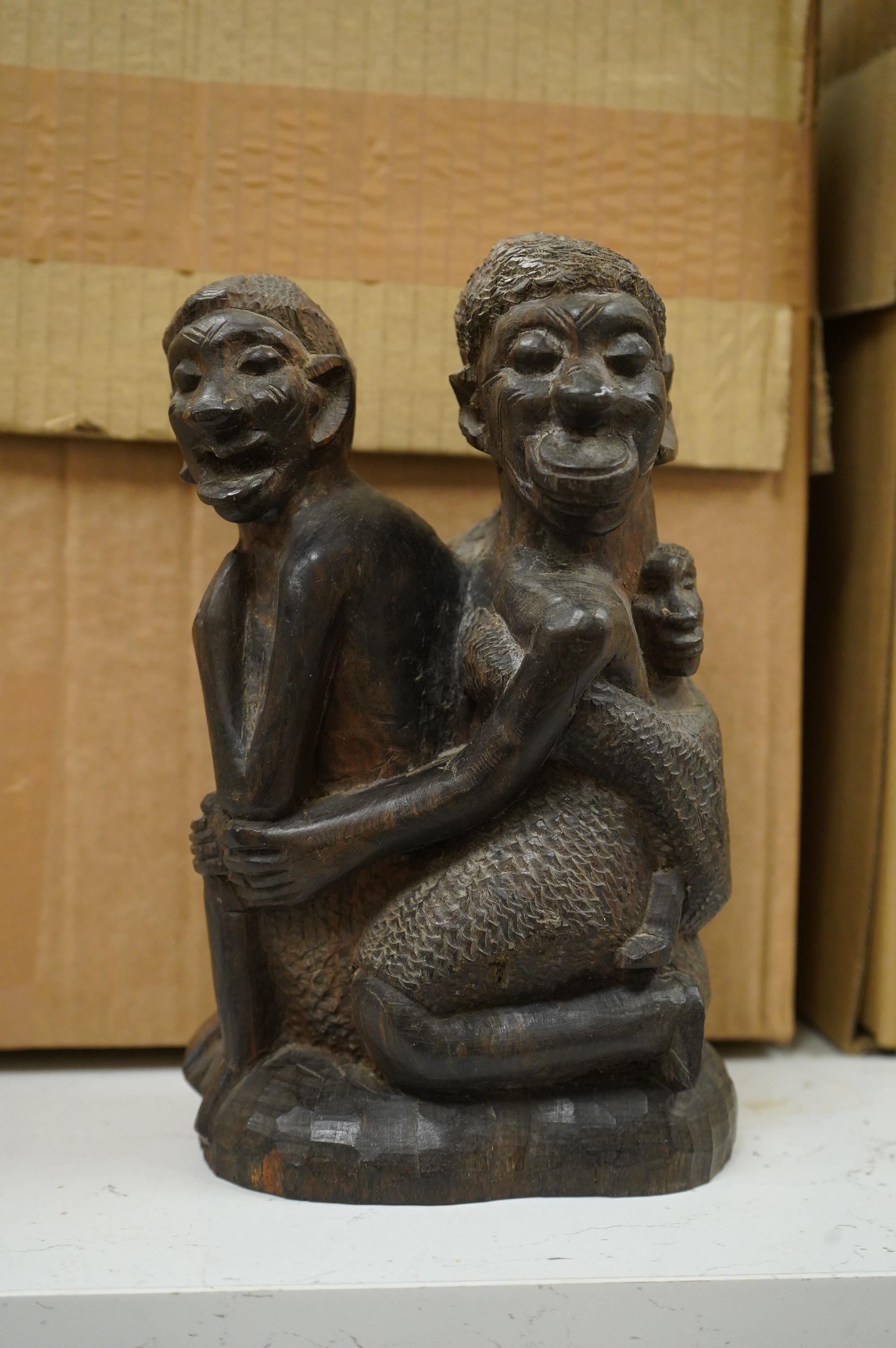 Five ethnographic items; an early 20th century chip carved Australian boomerang-60cm long , together with a later example, a Benin bonds of a warrior seated on a stool, a Makonde African carved figure group and an Africa